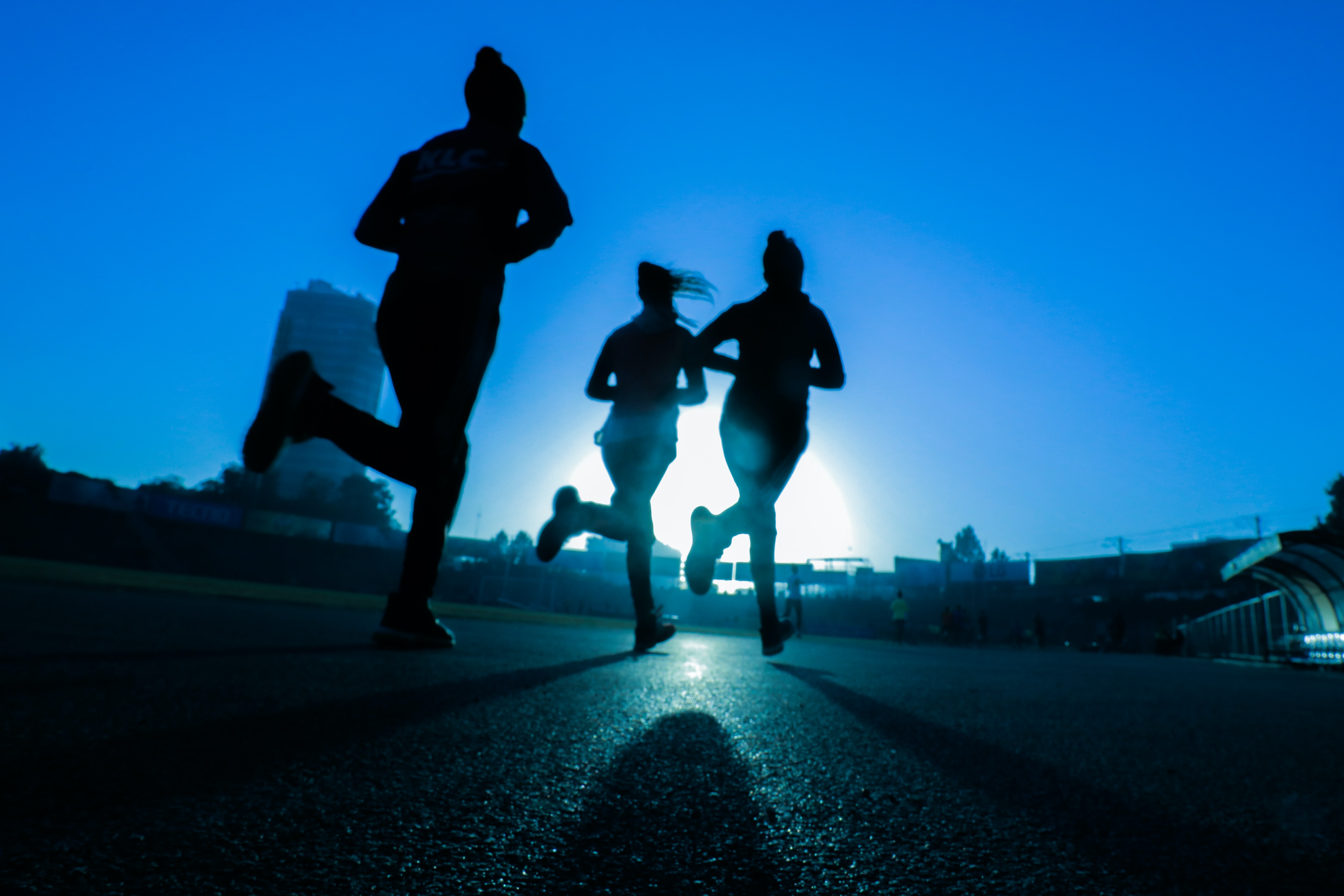 Silhouettes of runners at a running track